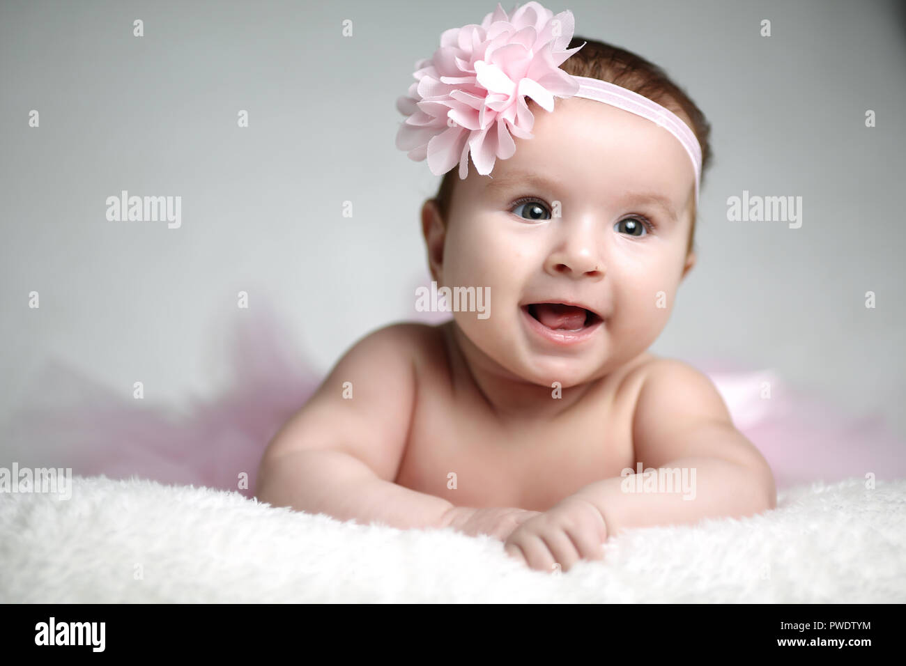 Funny baby girl lying on white Stock Photo