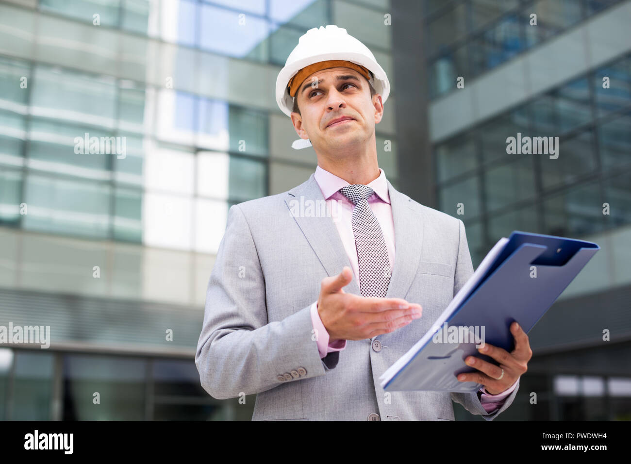 Businessman holding folder with documents and attentively reading Stock Photo