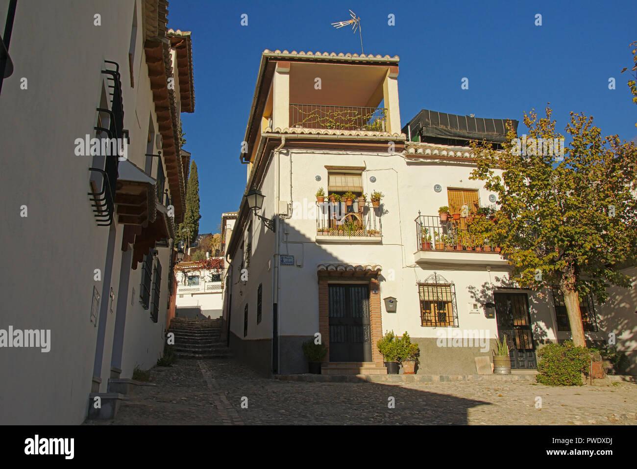 Narrow street with white houses in Albayzin neighbourhood, Granada Stock Photo