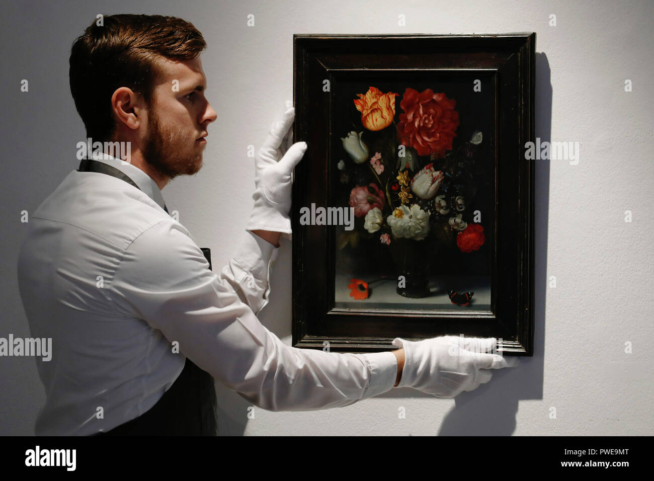 London, UK, 16th Oct 2018. Christie's art handler adjusts Dutch master Ambrosius Bosschaert, the Elder 's artwork 'Flowers in a berkemeier glass on a stone ledge' at Christie's AuctionHouse in London, UK, Tuesday October 16, 2017. The piece is expected to achieve up to £1.2million when is comes to auction as part of the Albada Jelgersma Collection sale during Christie's Classic Week in December. Photograph : Credit: Luke MacGregor/Alamy Live News Stock Photo