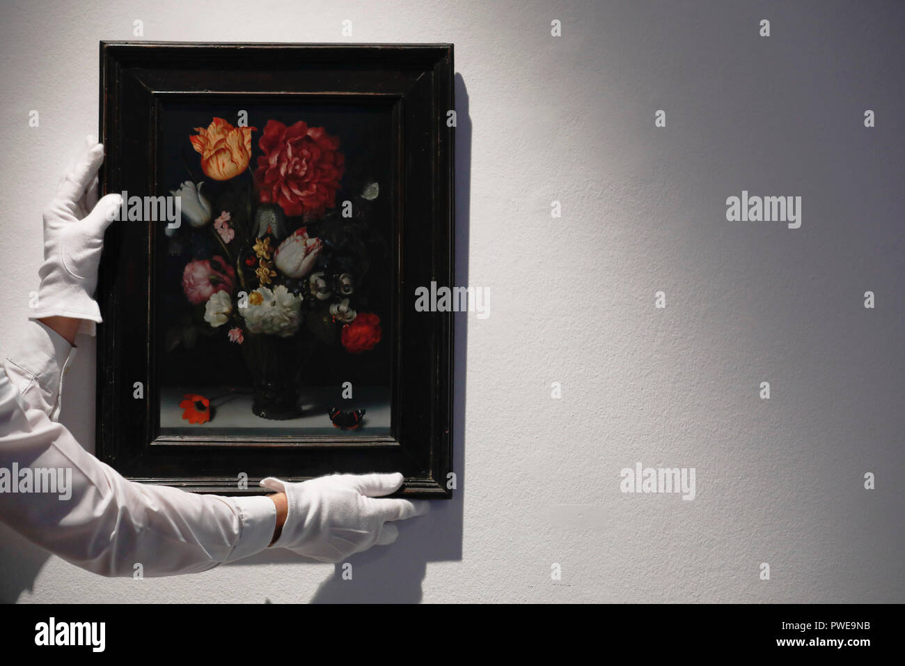 London, UK, 16th Oct 2018. Christie's art handler adjusts Dutch master Ambrosius Bosschaert, the Elder 's artwork 'Flowers in a berkemeier glass on a stone ledge' at Christie's AuctionHouse in London, UK, Tuesday October 16, 2017. The piece is expected to achieve up to £1.2million when is comes to auction as part of the Albada Jelgersma Collection sale during Christie's Classic Week in December. Photograph : Credit: Luke MacGregor/Alamy Live News Stock Photo