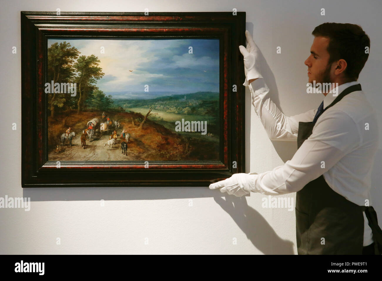 London, UK, 16th Oct 2018. A Christie's employee holds Dutch master Jan Breughel the Elder 's works 'An extensive wooded landscapef' at Christie's AuctionHouse in London, UK, Tuesday October 16, 2017. The piece is expected to achieve up to £5million when it comes to auction as part of the Albada Jelgersma Collection sale during Christie's Classic Week in December. Photograph : Credit: Luke MacGregor/Alamy Live News Stock Photo