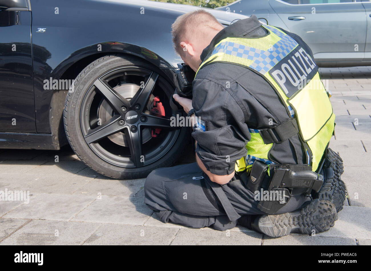 Melle, Lower Saxony. 16th Oct, 2018. A policeman documents a lowered Golf  GTI during a major inspection on the A30 motorway in the district of  Osnabrück. The main focus of the large-scale