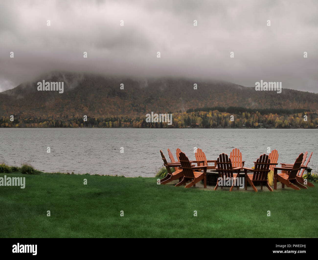 Adirondack Chairs around a fire pit with lake and mountain views Stock ...