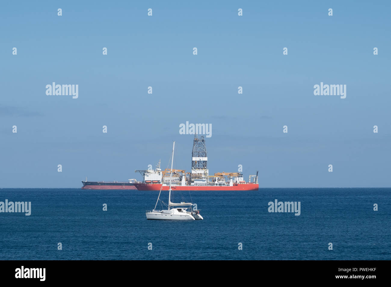 sailing boat, drilling ship and tanker on ocean horizon Stock Photo