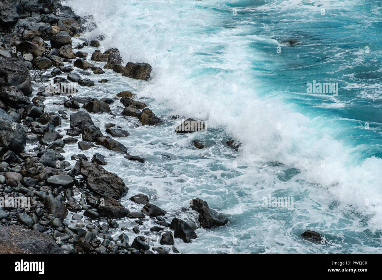 ocean waves on black pebble stone beach - Stock Photo