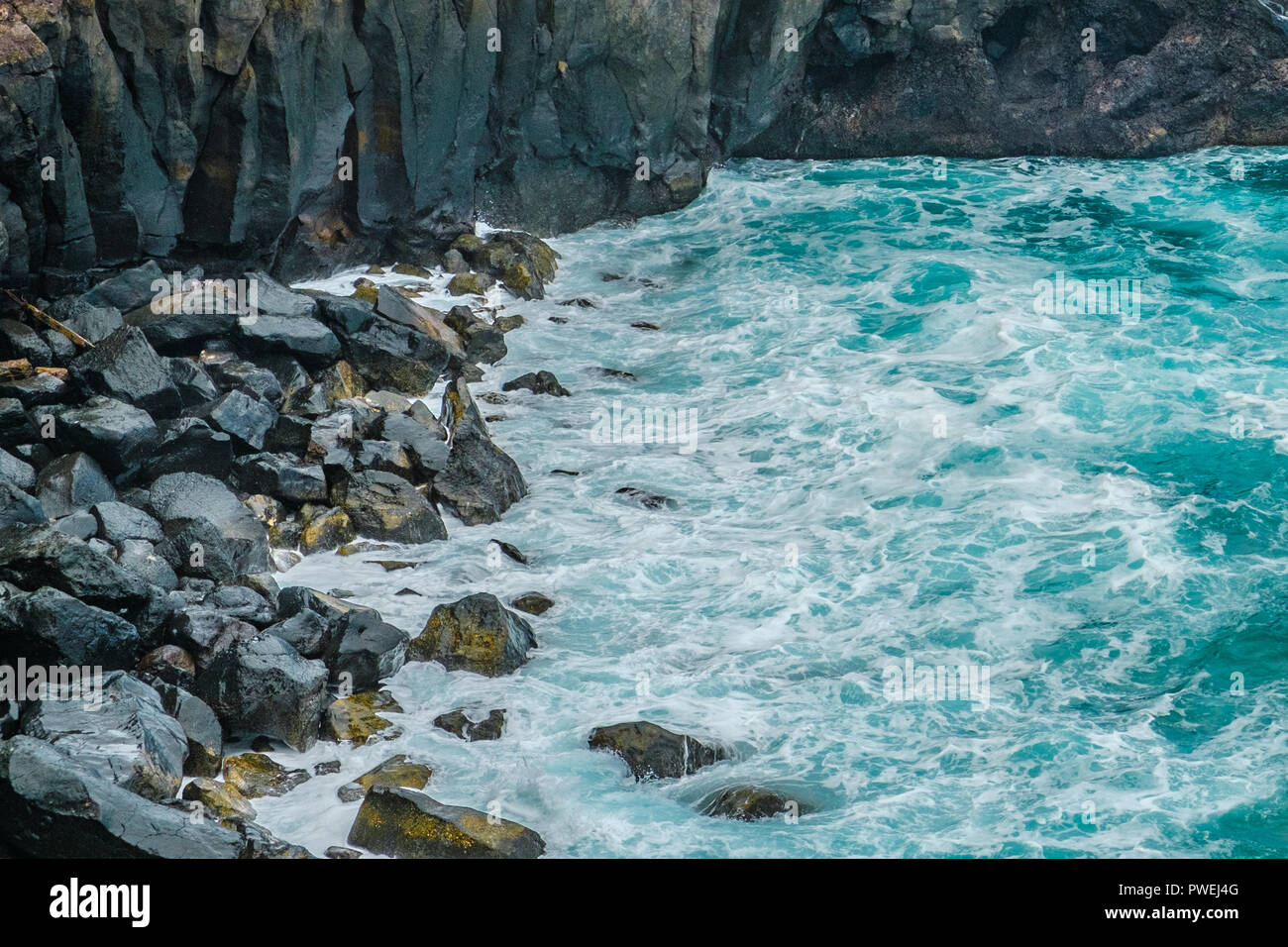 ocean waves on black pebble stone coast - Stock Photo