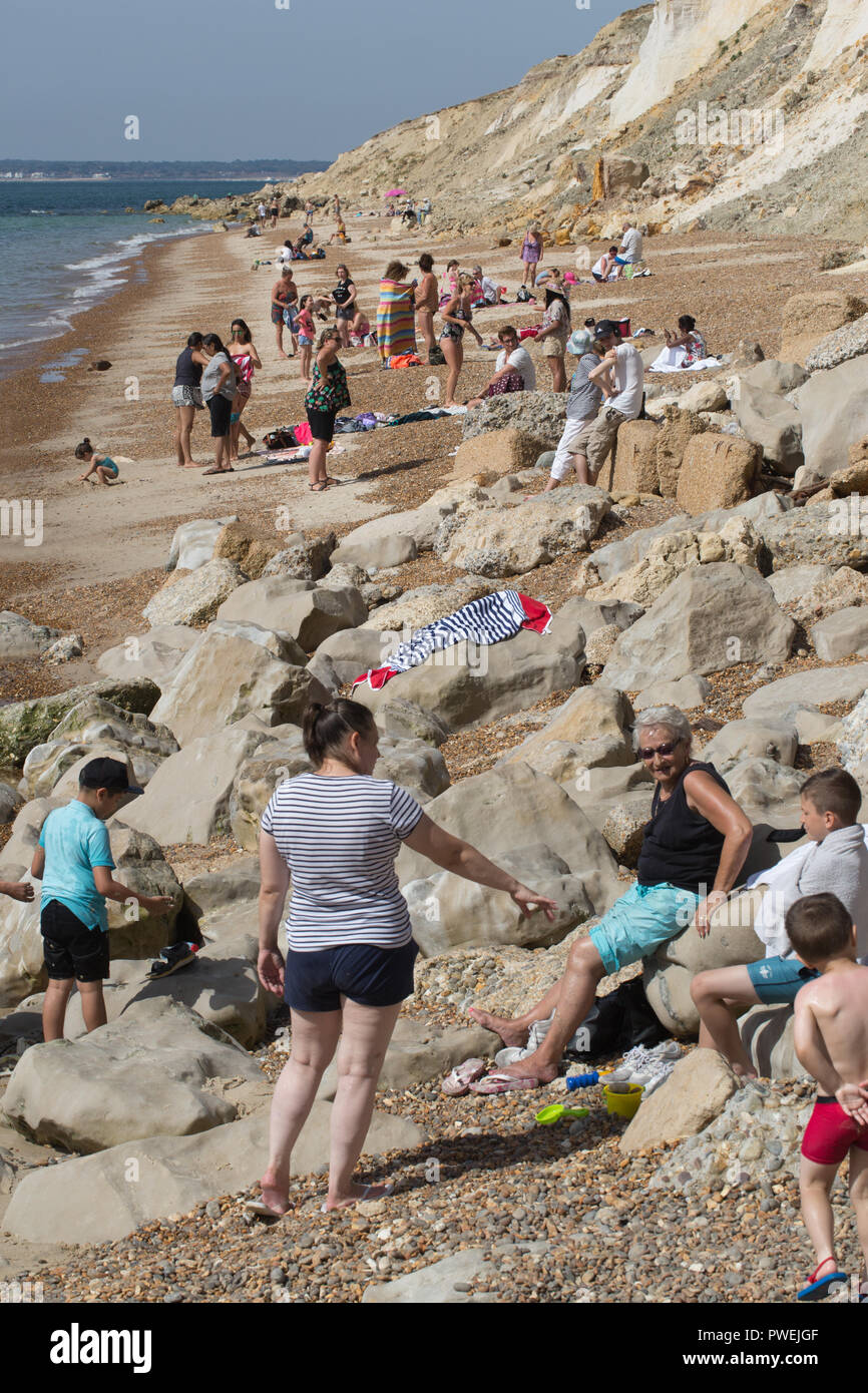Beach and shoreline of Alum Bay, Isle of Wight. Holiday makers enjoying the sea and sand at the base of the cliffs. Stock Photo