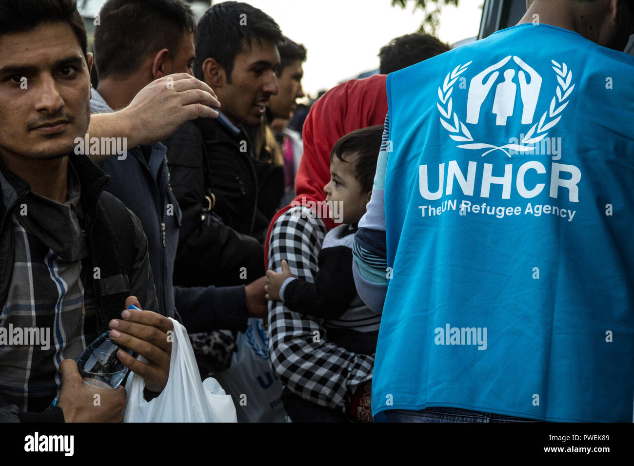 BERKASOVO, SERBIA - OCTOBER 10, 2015: Worker of the UNHCR, the United Nations Agency for refugees, standing in front of a crowd of refugees, including Stock Photo