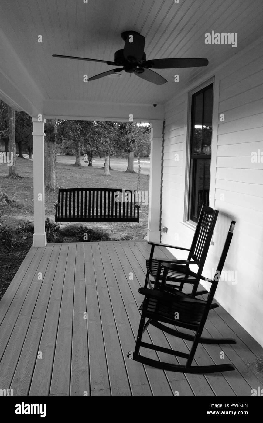 Rocking chairs and a swing bench on a traditional front porch of a home in North Carolina. Stock Photo