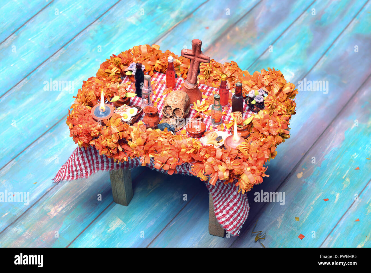 Mexican Day of the dead altar with skull, pan de muerto, drinks, cempasuchil flowers and candles Stock Photo