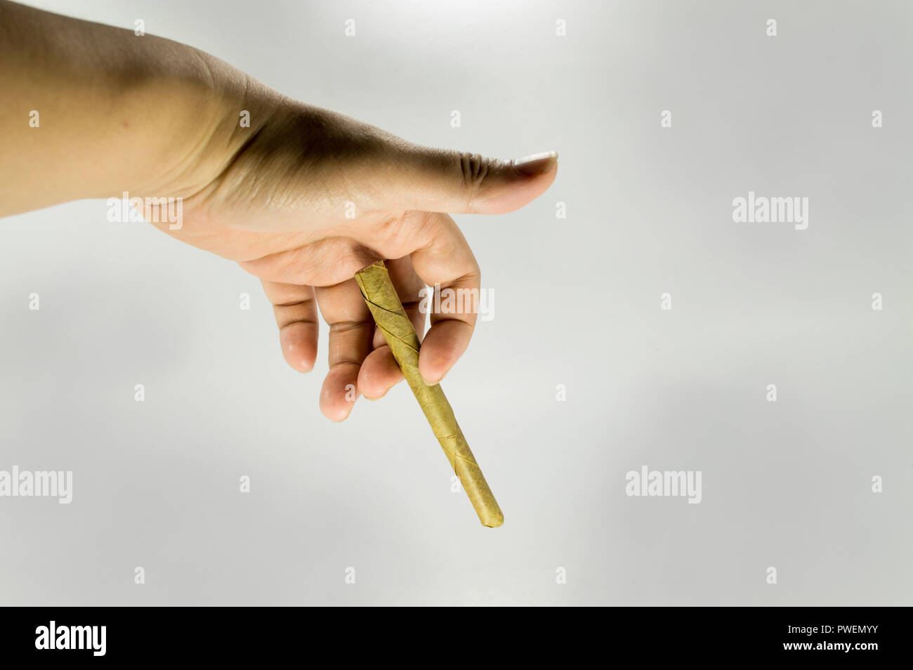 Hand holding a Native southeast asia cigarette. Stock Photo