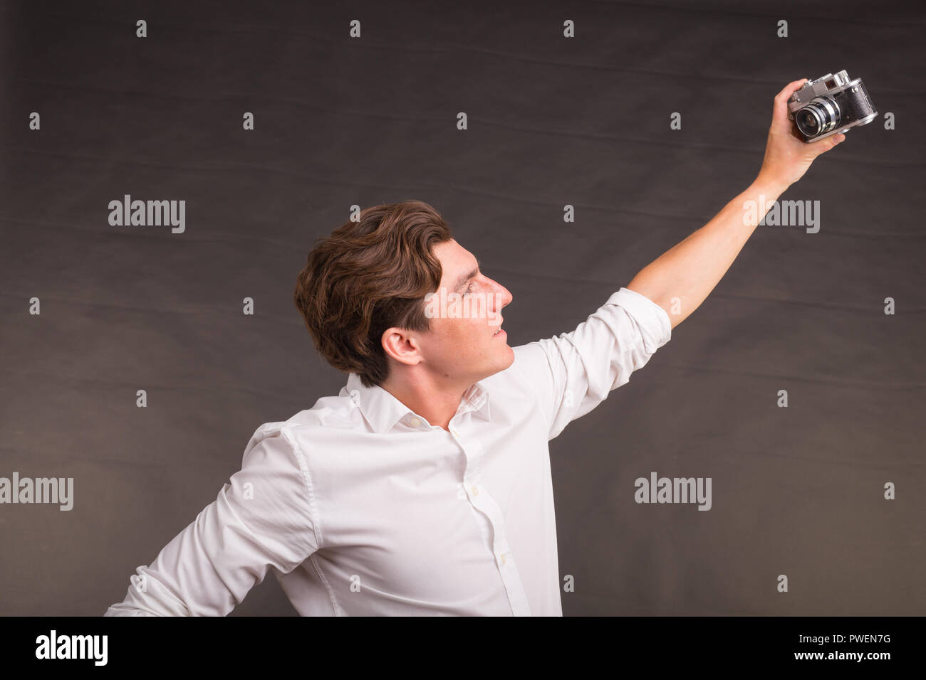 Technology, photogtaphy and people conecpt - Handsome man in white shirt taking a selfies Stock Photo