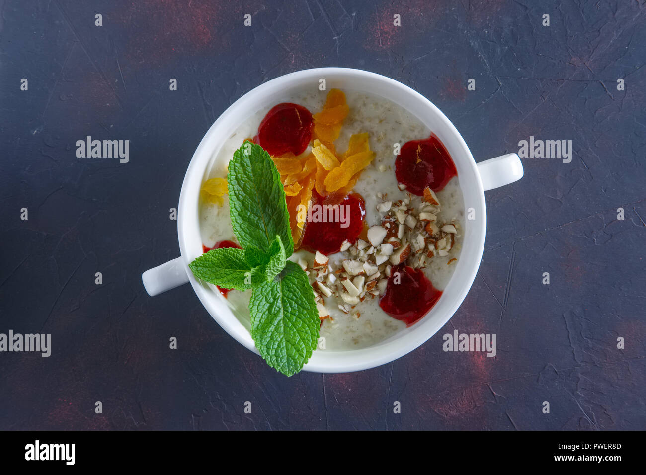 Healthy breakfast oatmeal with dried apricots, almond and strawberry