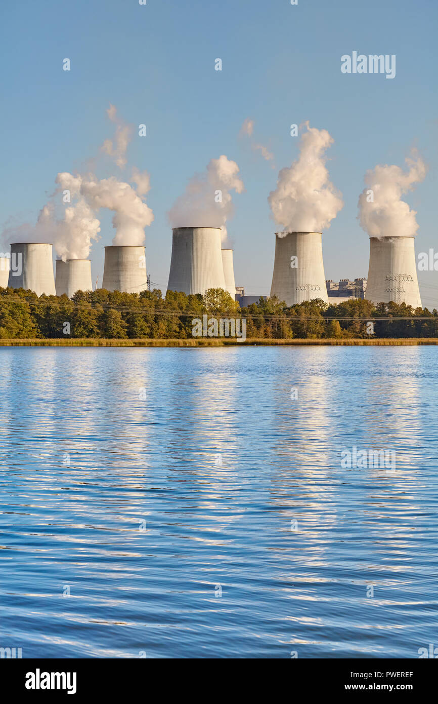 Smoking chimneys reflected in water, environmental pollution concept. Stock Photo