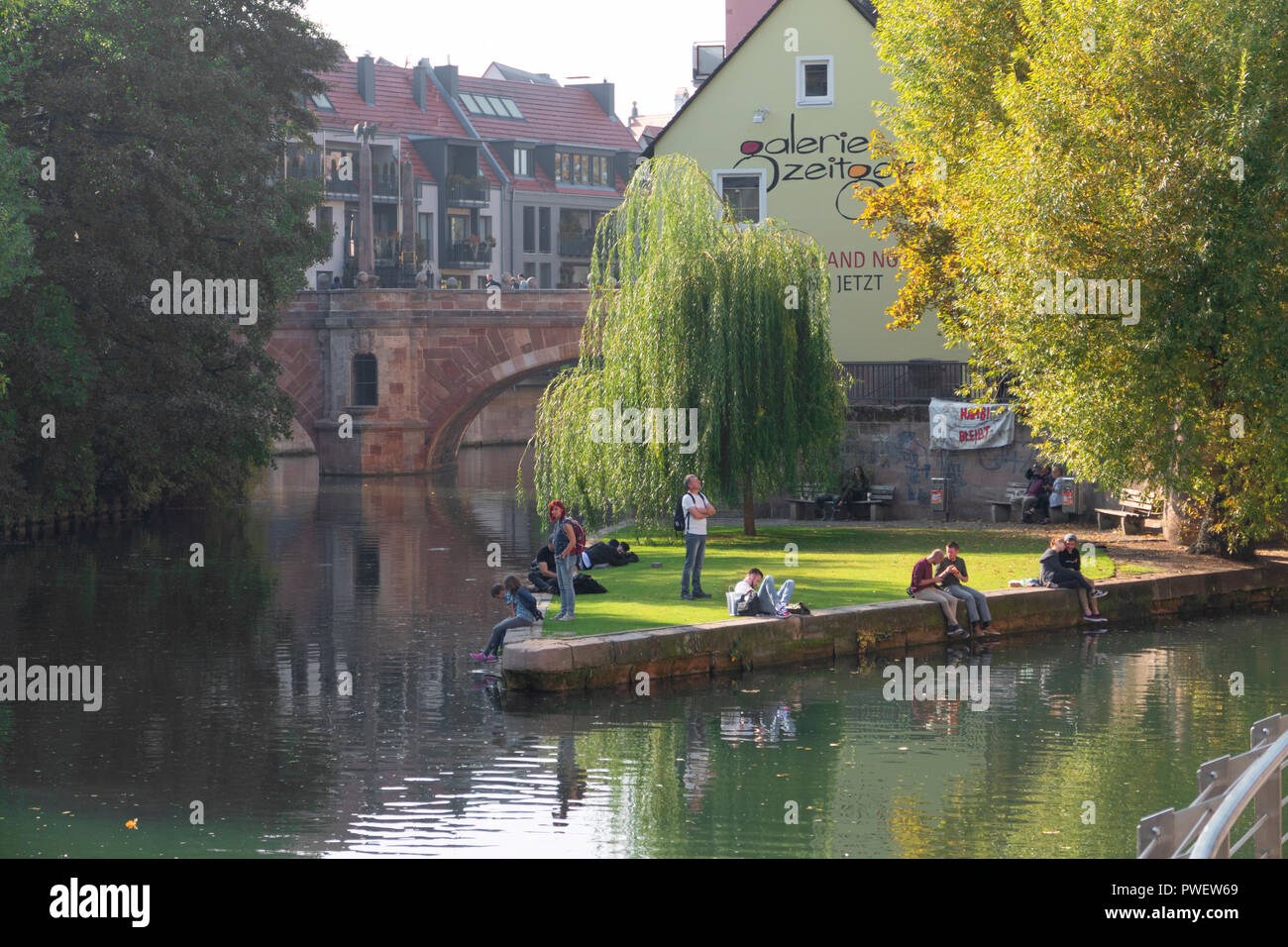 People enjoy a sunny afternoon at the Pegnitz river in Nuremberg, Germany. Stock Photo