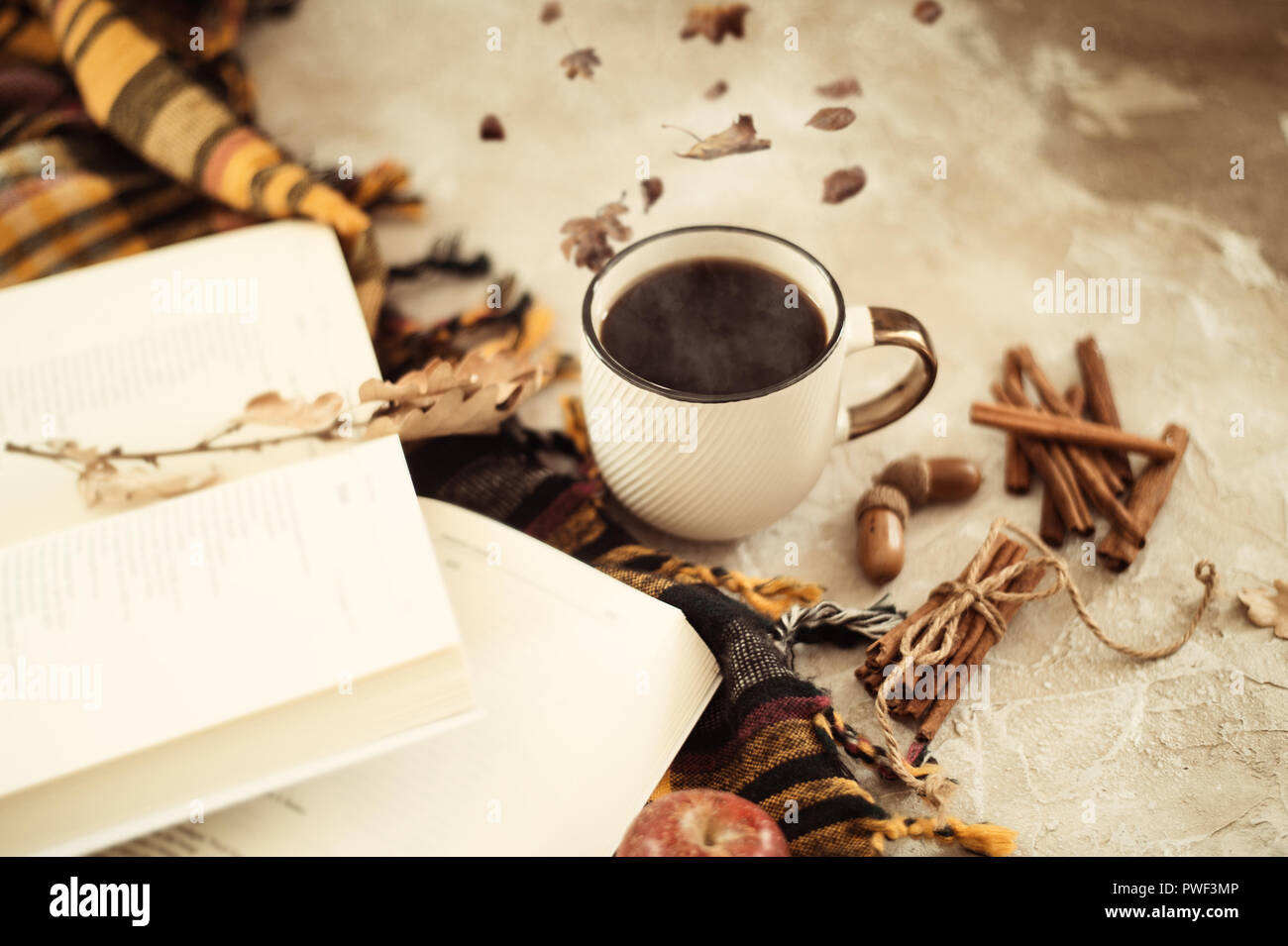 Autumn composition. Cup of coffee, blanket, autumn leaves, cinnamon sticks on beige background. Flat lay, top view. Stock Photo