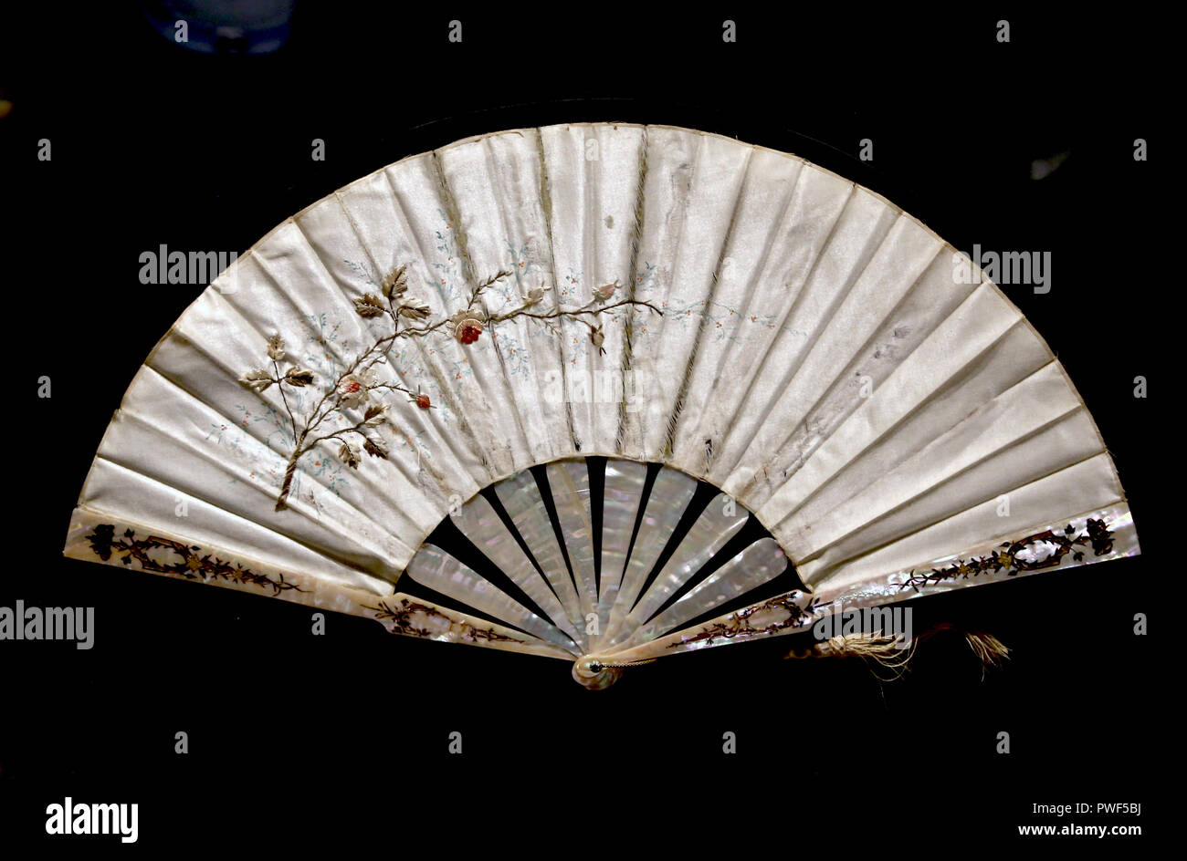 Decorated folding fan. China, about 1900. Mother of pearl and satin silk. 8 stretchers. Museu do Oriente, Lisbon. Stock Photo