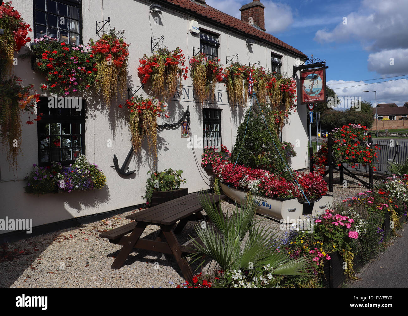 The Anchor Inn in Thornbury, Gloucestershire, UK continues the local tradition of displaying hanging flower baskets; was Britain in Bloom winner. Stock Photo