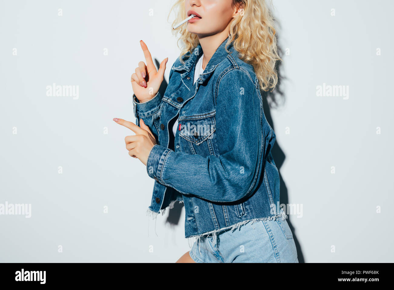 Portrait of the young girl in jeans clothes with cigarette smoking isolated  on white background Stock Photo - Alamy