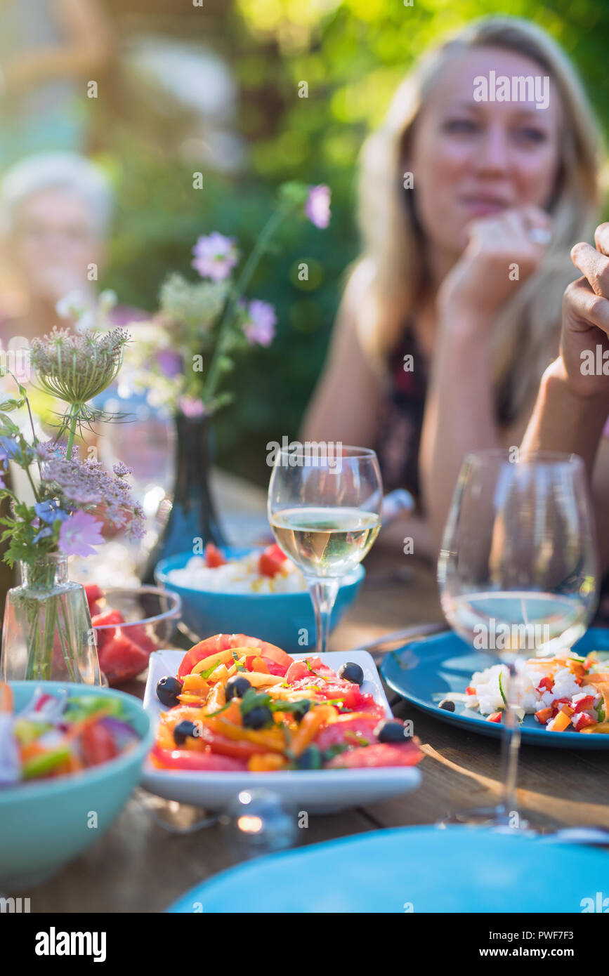 family having lunch in the garden , closeup on tomatoes salad Stock Photo