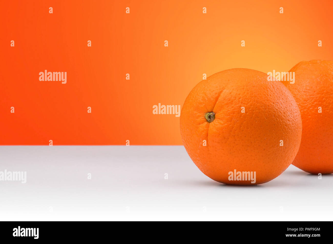 Group of oranges isolated on an orange and white background with space ...