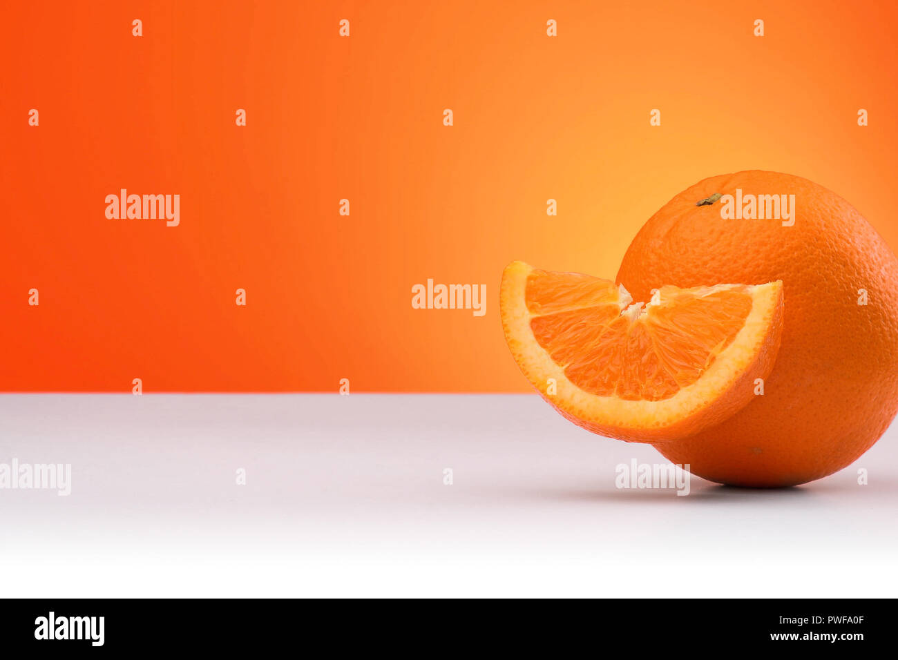 Group of oranges isolated on an orange and white background with space ...