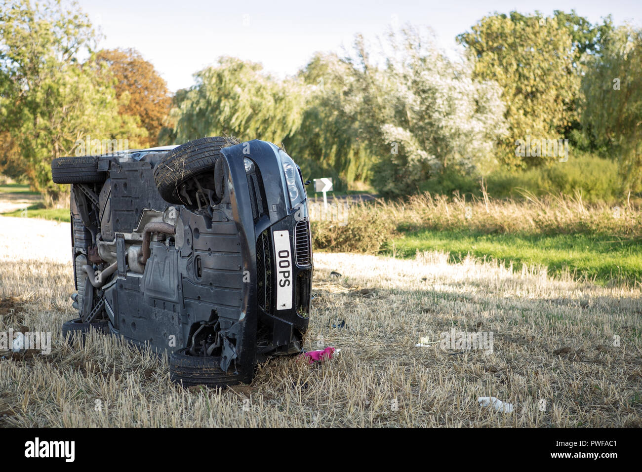 car on its rolled onto its side in a field after going to fast around