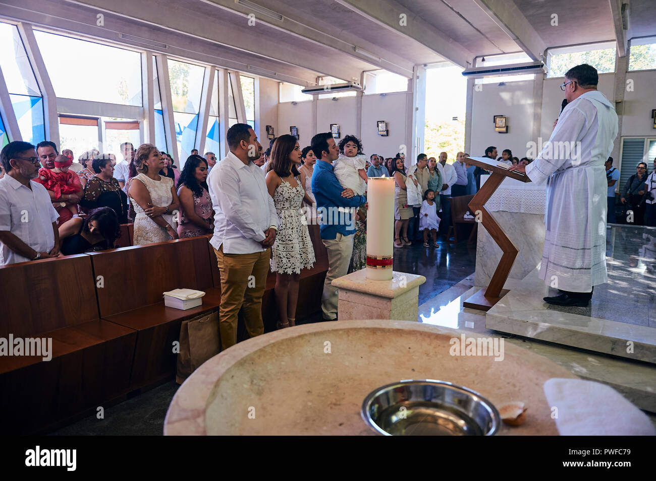 MERIDA, YUC/MEXICO - NOV 18, 2017: Catholic priest celebrates mass for a collective baptism Stock Photo