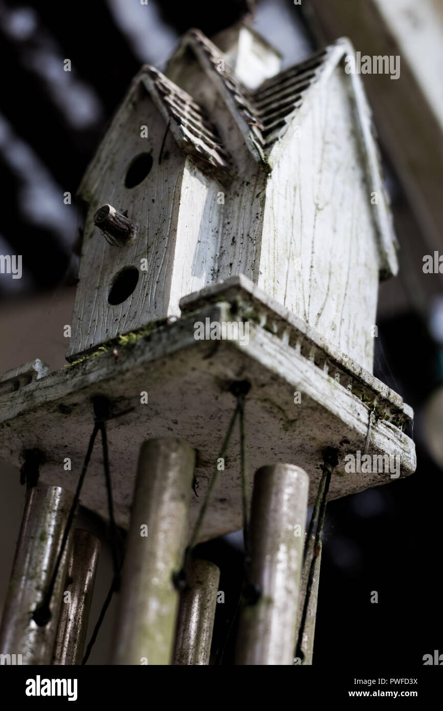 Abstract bird house windchime dirty and weathered with moss Stock Photo