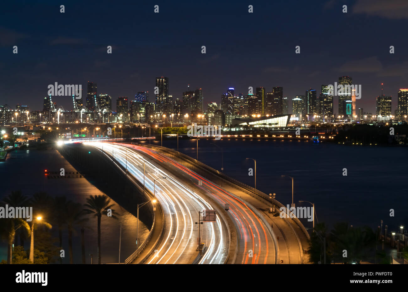 The nighttime skyline of Miami as seen from above the traffic of MacArthur Causeway, a heavily traveled bridge connecting Miami to Miami Beach Stock Photo