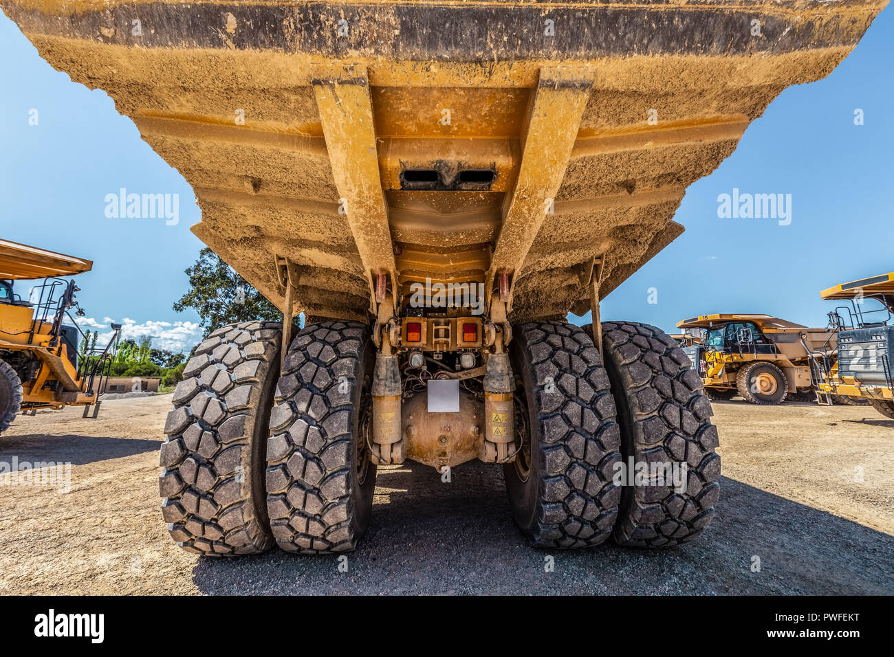 Rear closeup view of huge dirty dumper truck Stock Photo