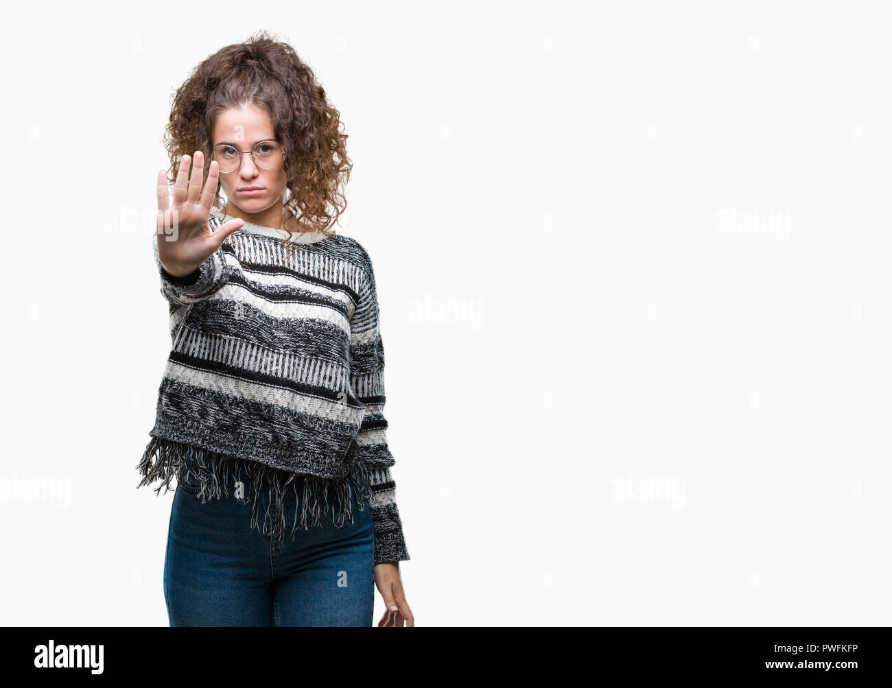 Beautiful brunette curly hair young girl wearing glasses over isolated background doing stop sing with palm of the hand. Warning expression with negat Stock Photo