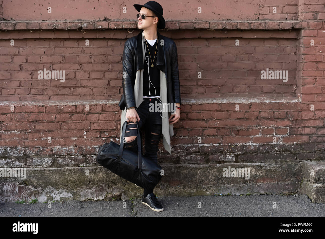 Young man posing with a trendy outfit against a urban background Stock ...
