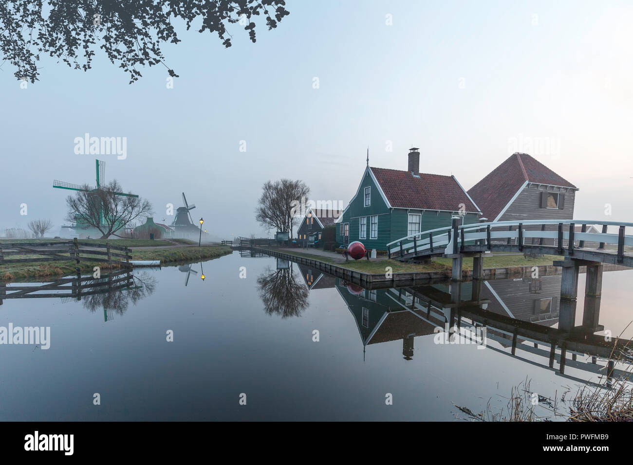 Beaucoutif typical Dutch wooden houses architecture mirrored on the calm canal of Zaanse Schans located at the North of Amsterdam, Netherlands Stock Photo