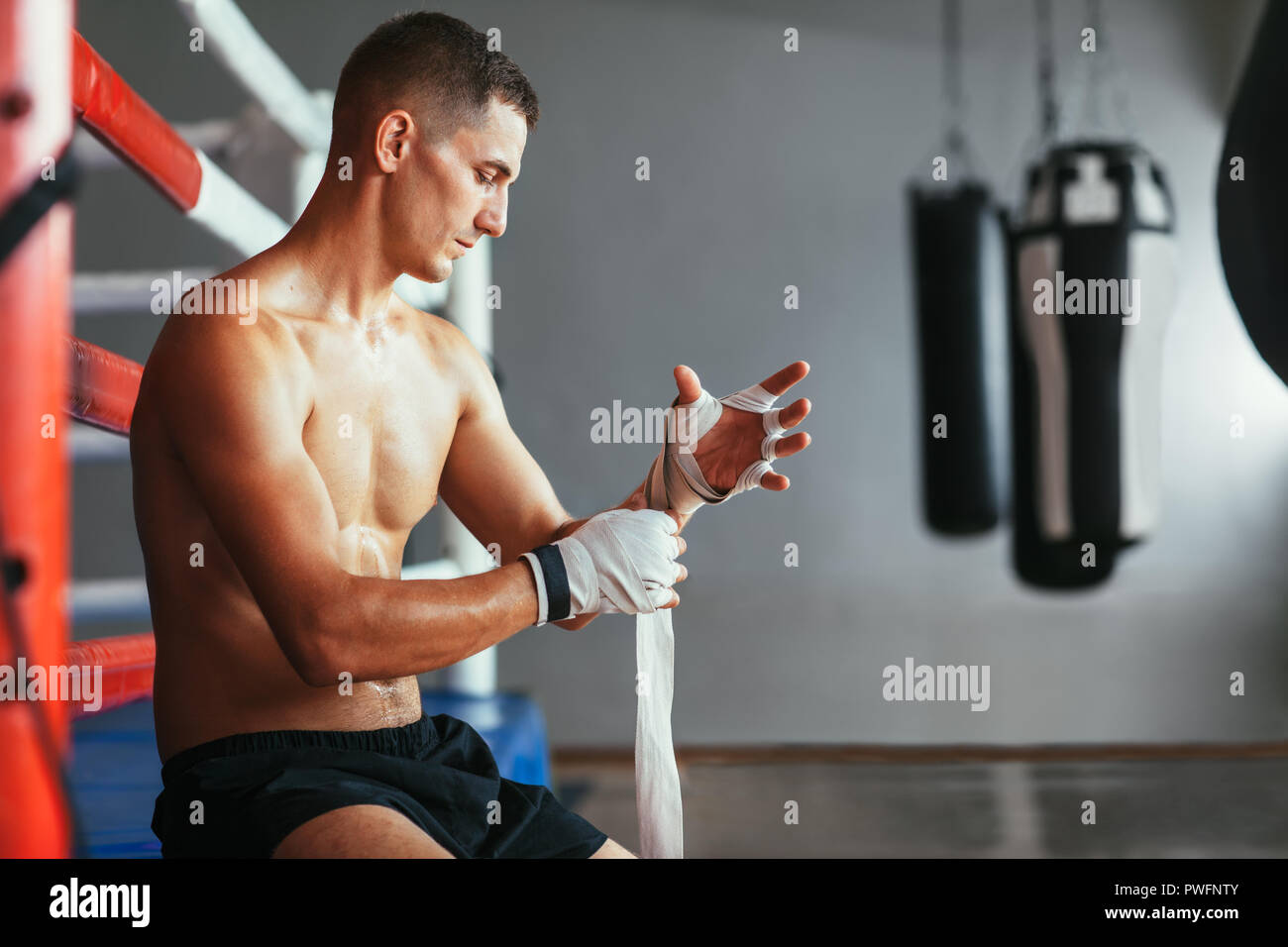 Male boxer is wrapping hands with boxing wraps. Boxing concept Stock