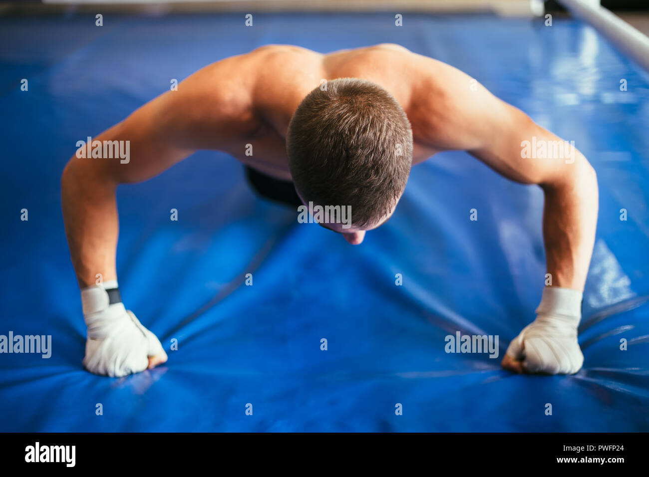 Athlete man doing pushup exercise in gym Stock Photo