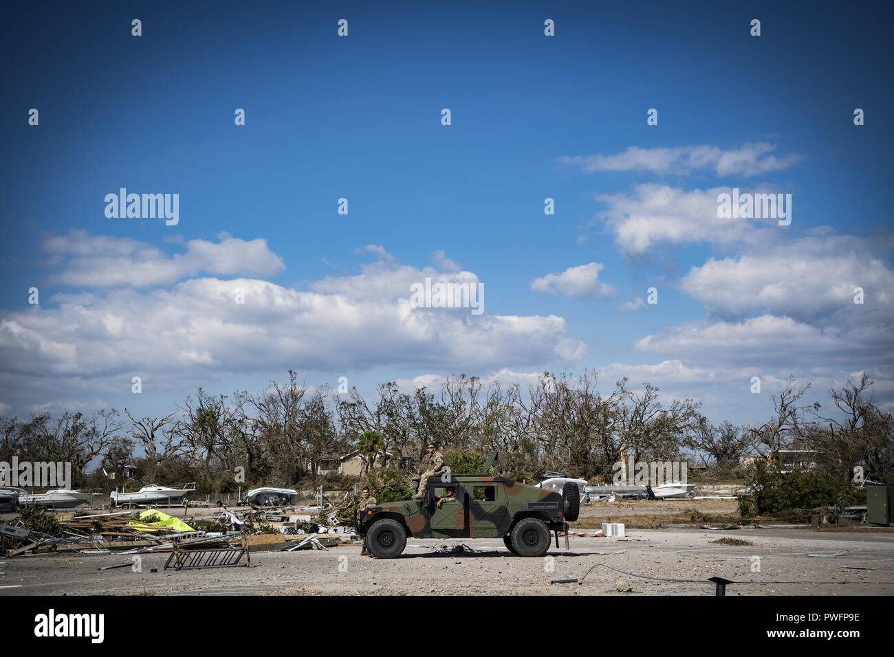 Airmen from the 820th Base Defense Group, Moody Air Force Base, Georgia, survey the wreckage on the marina of Tyndall Air Force Base, Florida, Oct. 14, 2018, following the devastation caused by Hurricane Michael, October 14, 2018. Air Combat Command has mobilized multiple squadrons across the major command to aid in the restoration of base functions following massive damages from high winds. (U.S. Air Force photo by Senior Airman Keifer Bowes). () Stock Photo