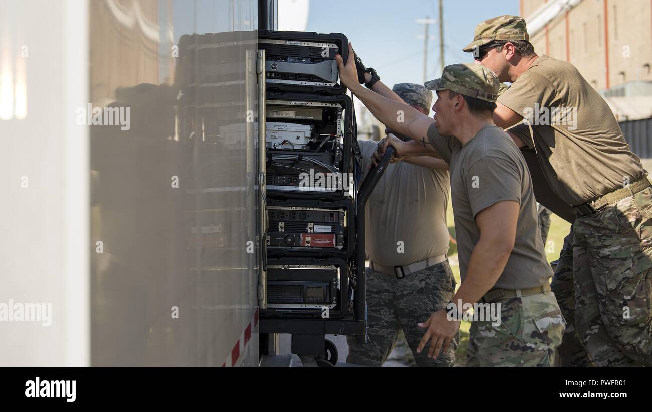 Service members from the Joint Communications Support Element and the 290th Joint Communications Support Squadron, load communication servers into a trailer before relocating to provide internet and phone capabilities to another area in need, Oct. 13, 2018, following Hurricane Michael's devastating strike, October 13, 2018. These Total Force experts can install, operate and enhance communication services and then relocate in a matter of hours, providing critical command and control whether it is for the warfighter abroad or to help our Florida family recover from the storm. (U.S. Air Force pho Stock Photo