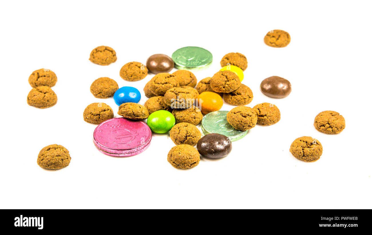 Bunch of pepernoten cookies, sweets and chocolate money frontal view on white background for annual Sinterklaas holiday event in the Netherlands on de Stock Photo