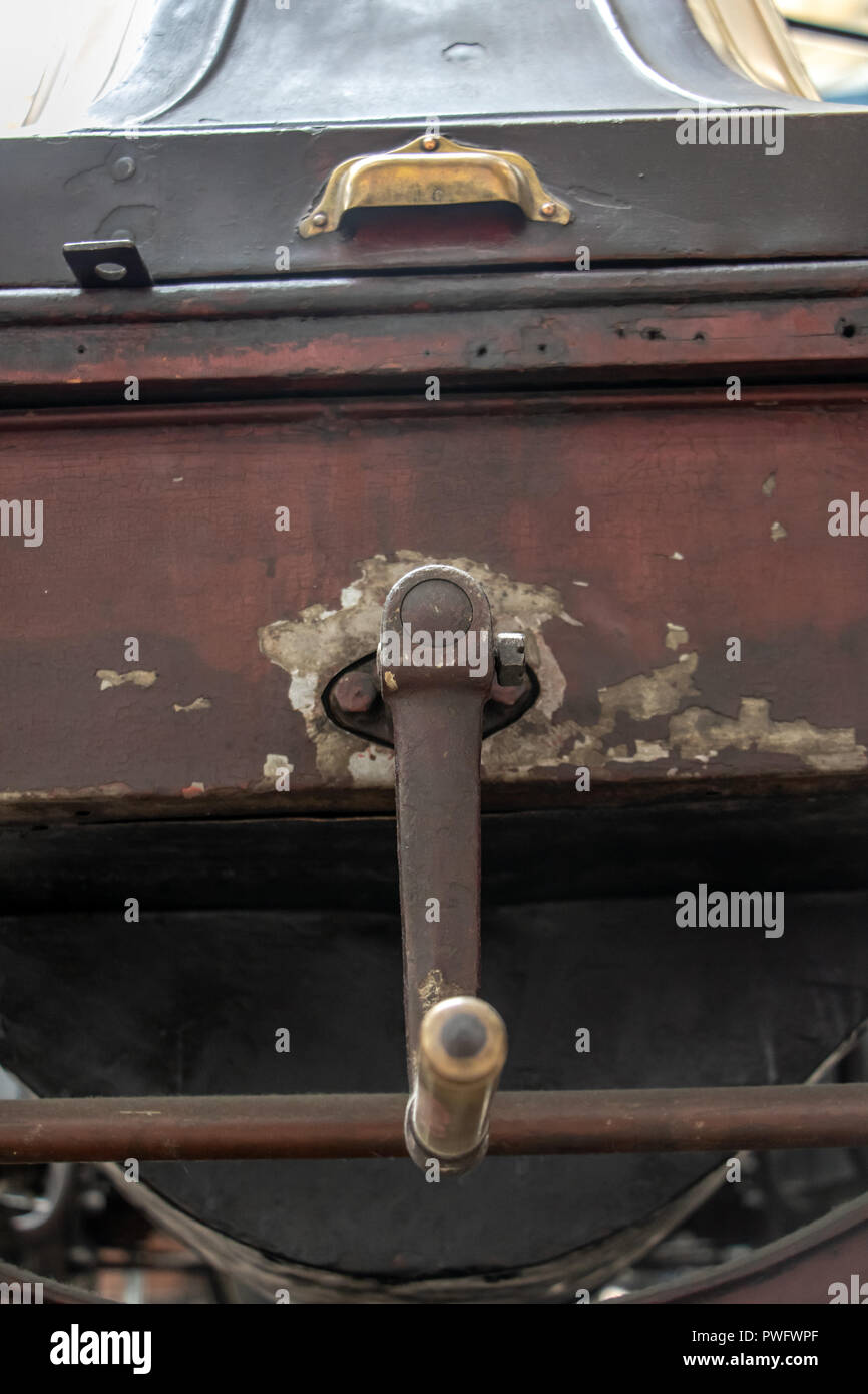 An old antique car with a hand crank for start, close up. The starter handle on the Renault AX car, year 1909. Stock Photo