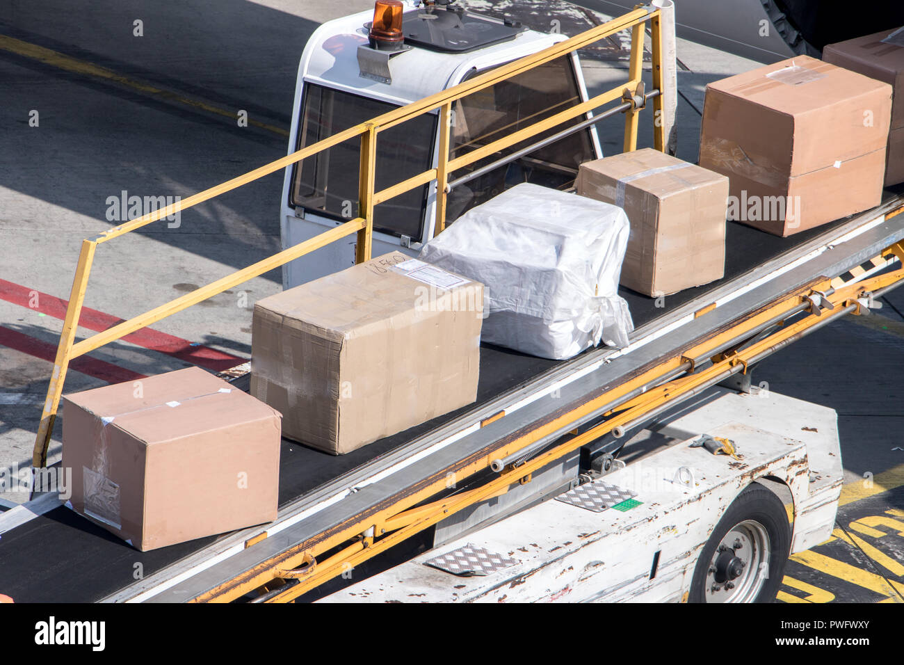 Unloading the packet from the fuselage of aircraft. The packages ride on the conveyor when loading the air plane. Stock Photo