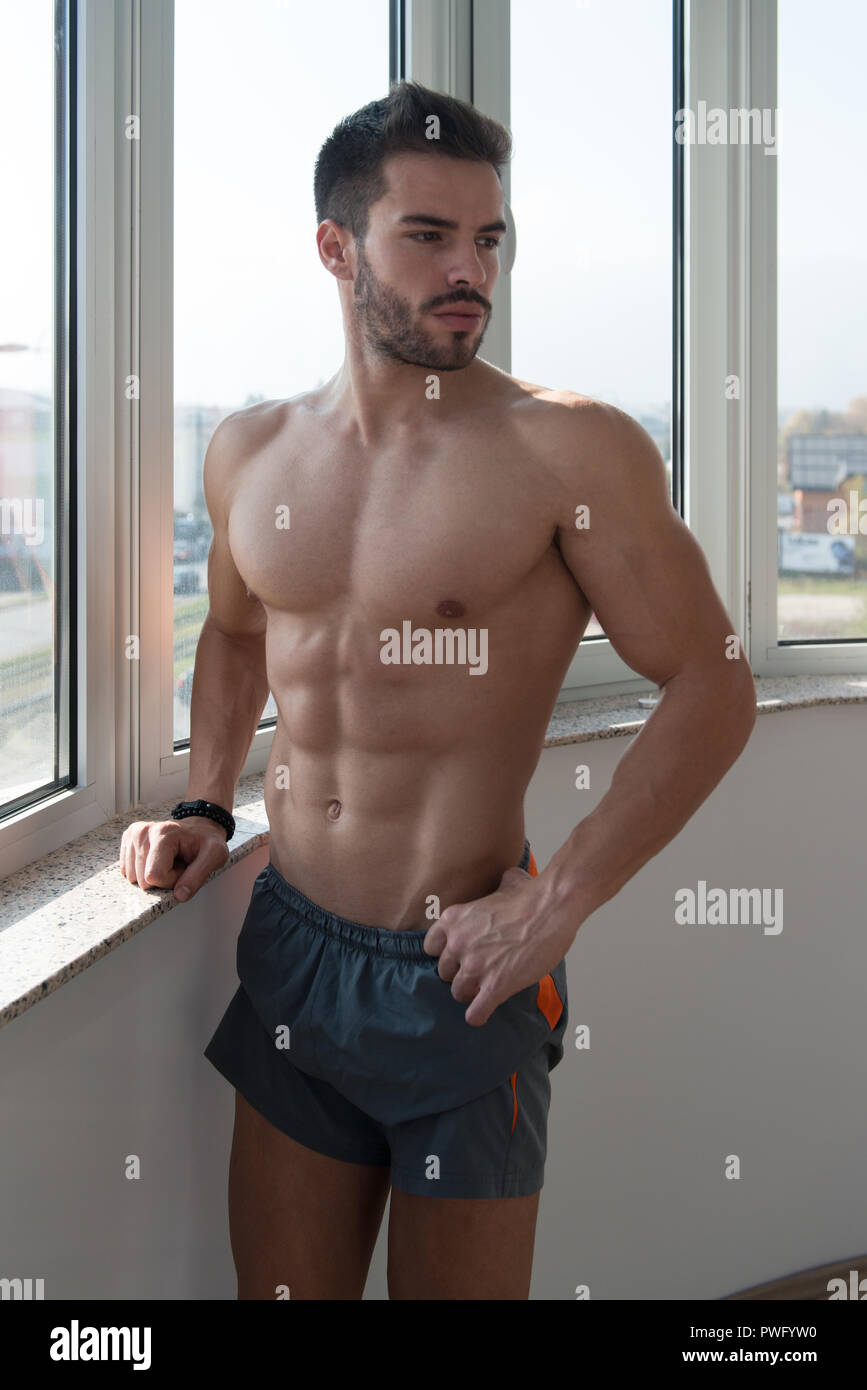 Good Looking And Attractive Young Athlete With Muscular Body Sitting On  Bench And Relaxing In Gym Stock Photo - Alamy