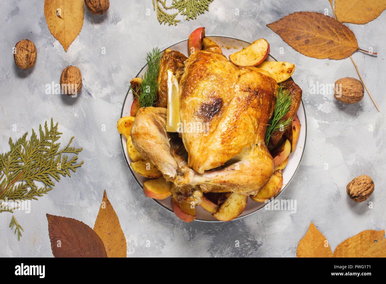 Roasted turkey with apples on a rustic concrete table decorated with ...