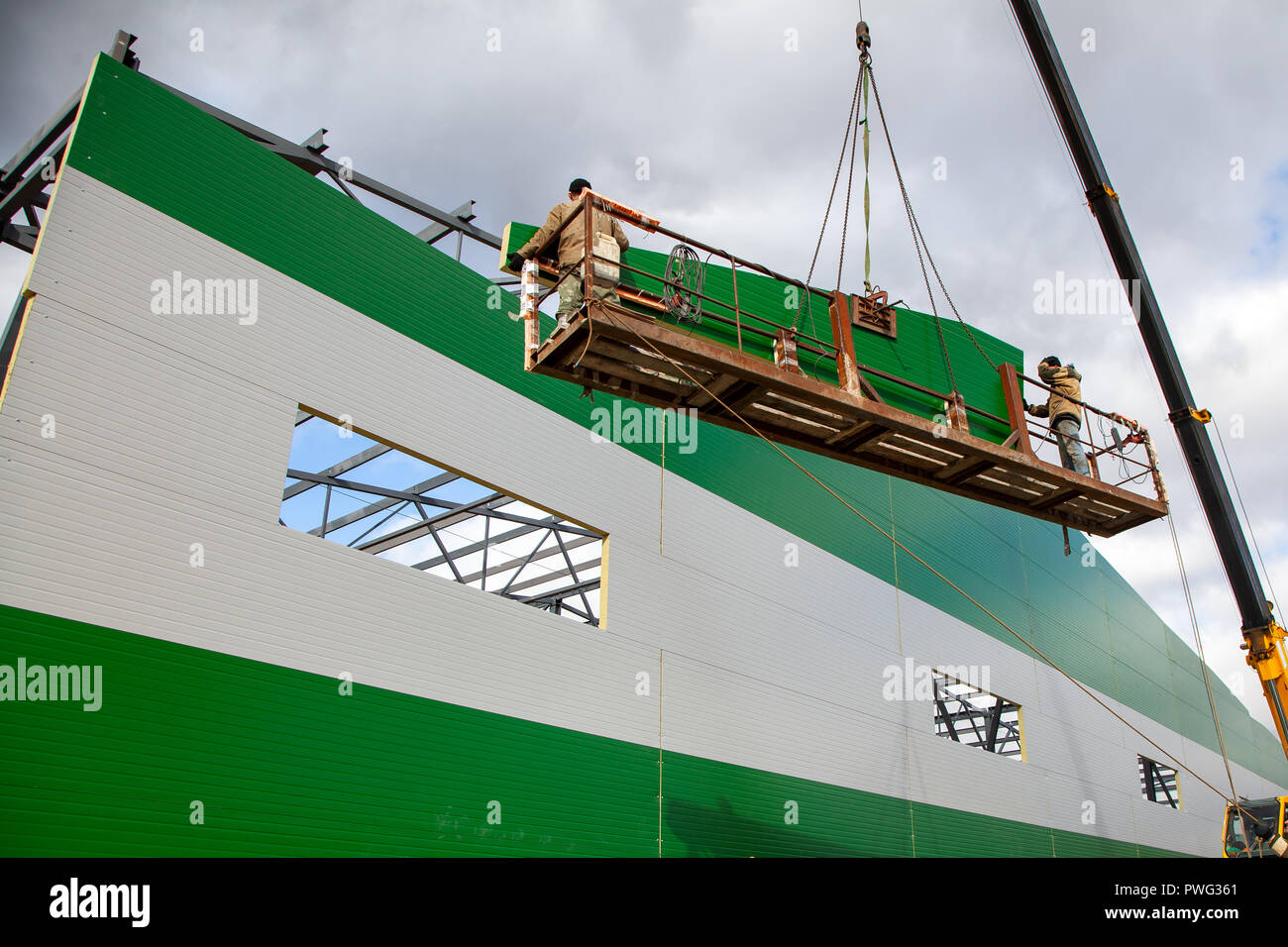 The builders are building a building of metal structures at a height in