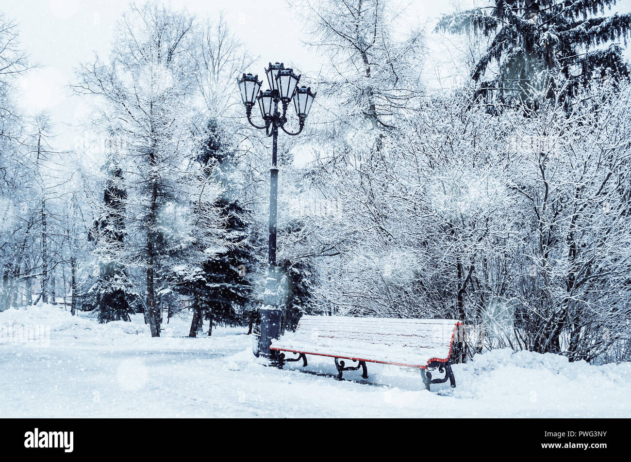 Winter landscape with falling snowflakes - bench covered with snow ...
