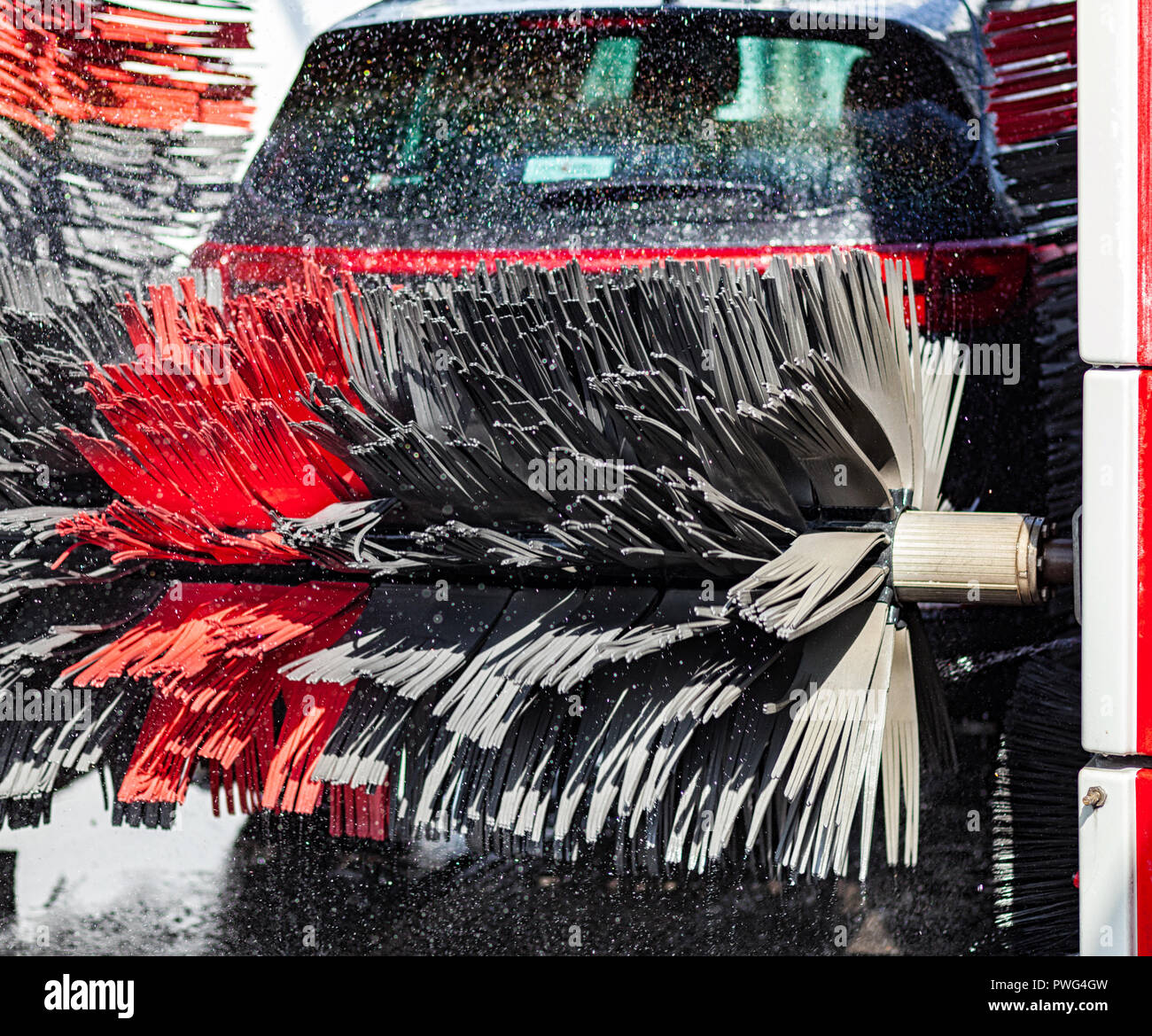Black car in automatic car wash rotating red and black brush. Washing  vehicle Stock Photo - Alamy