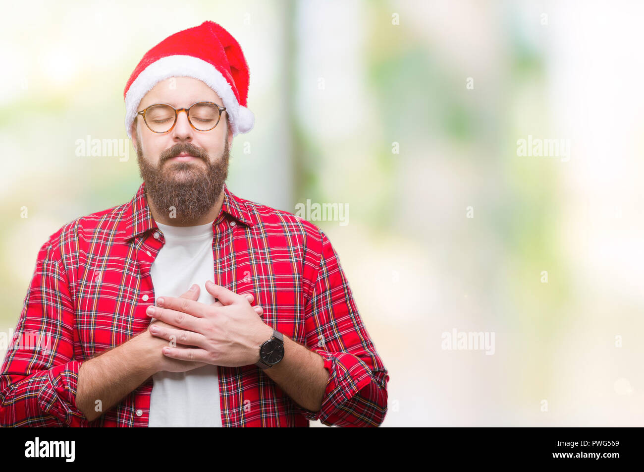 Young caucasian man wearing christmas hat over isolated background ...