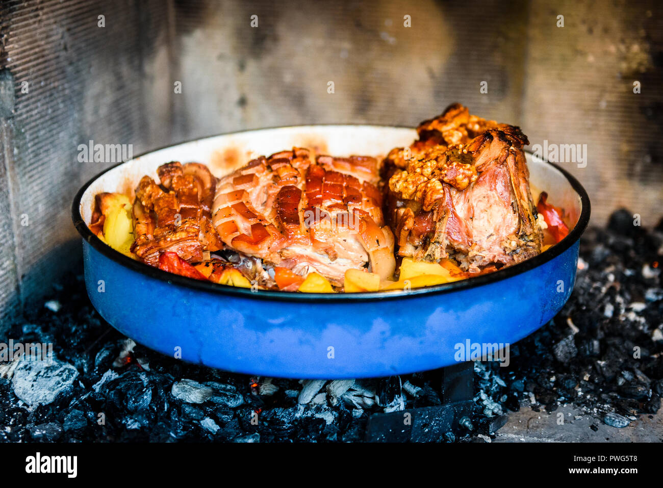 Preparing and cooking pork roast in traditional metal pot Peka. Meat