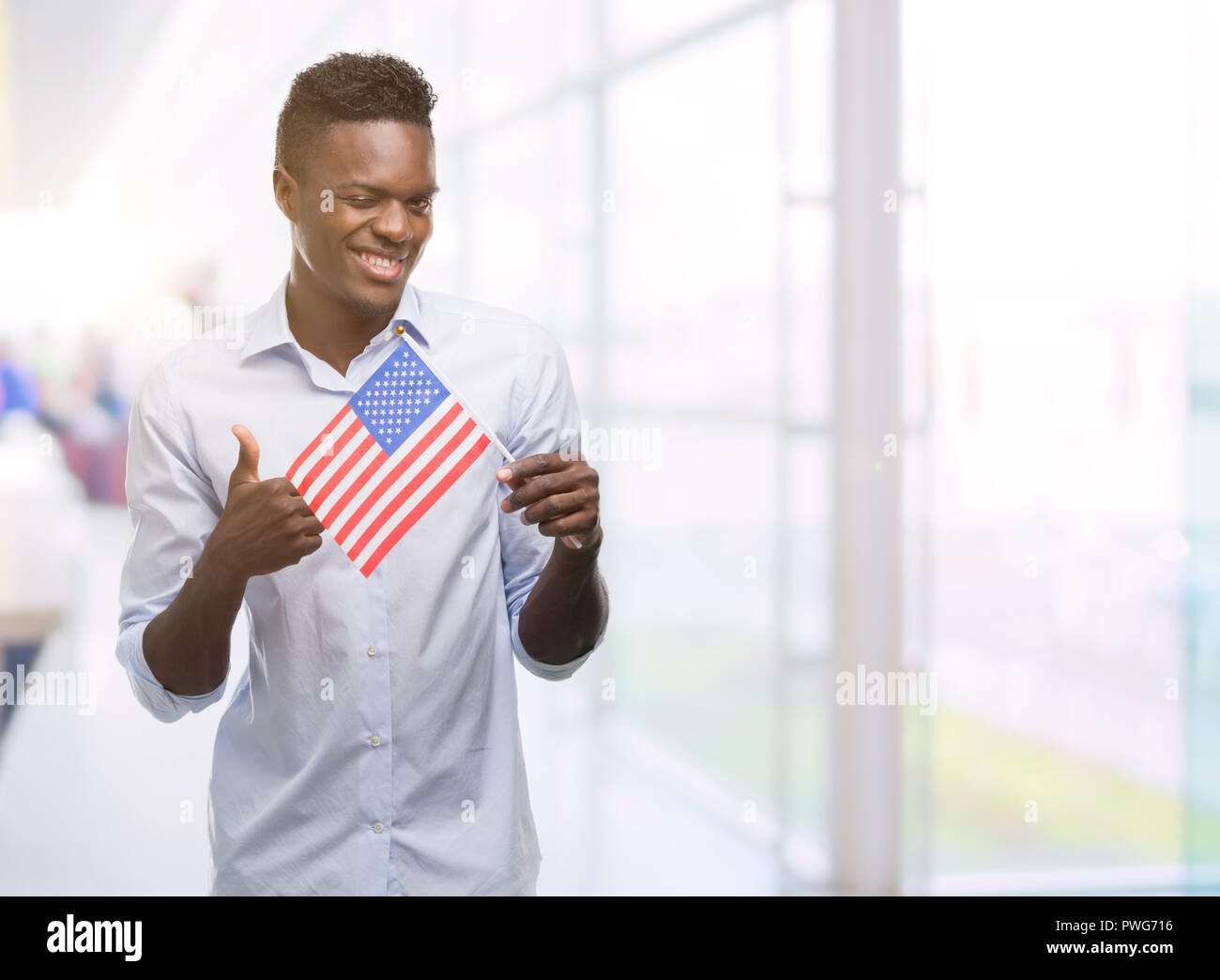 Young african american man holding USA flag happy with big smile doing ...